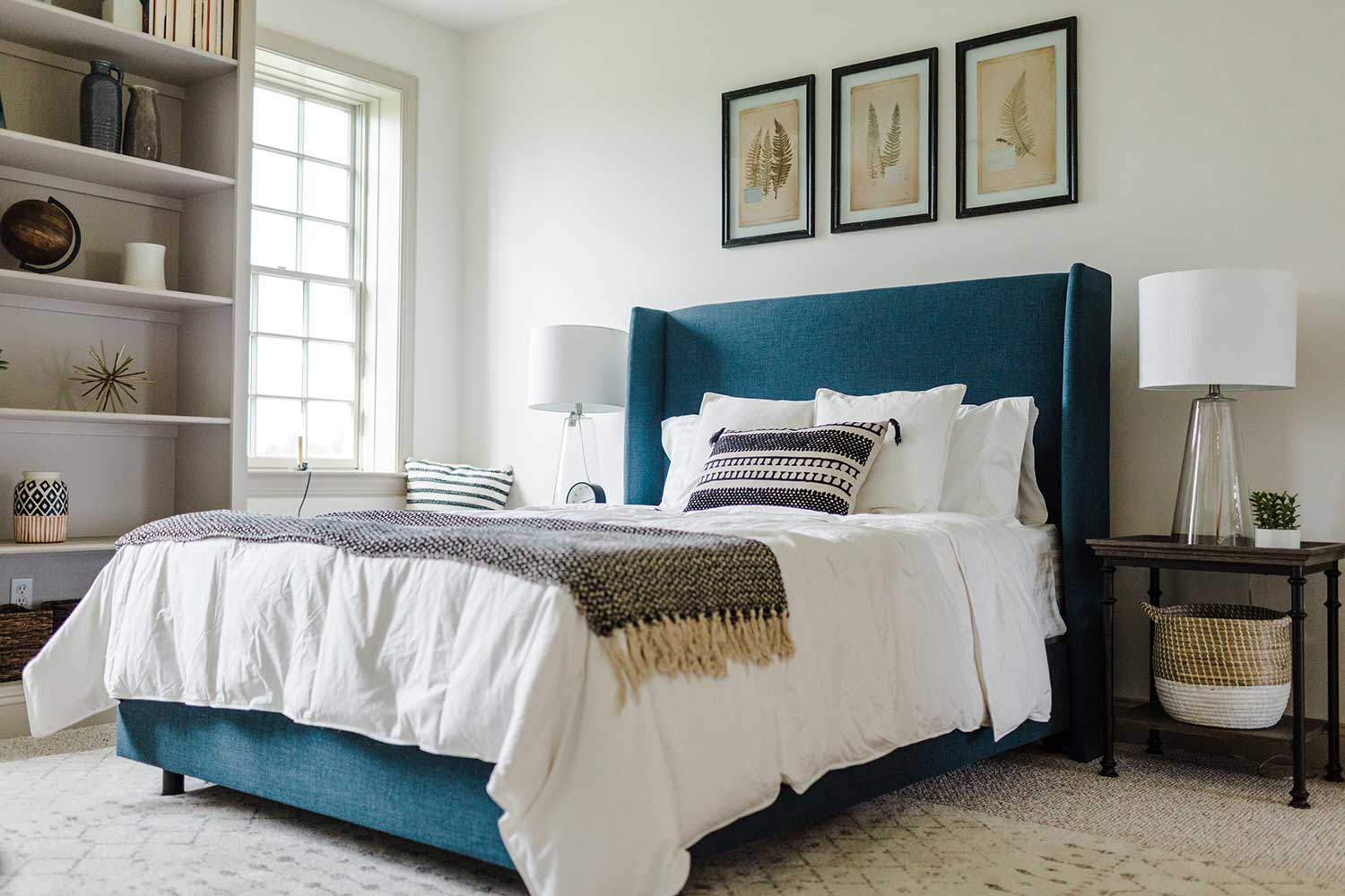 A bedroom with a teal upholstered bed