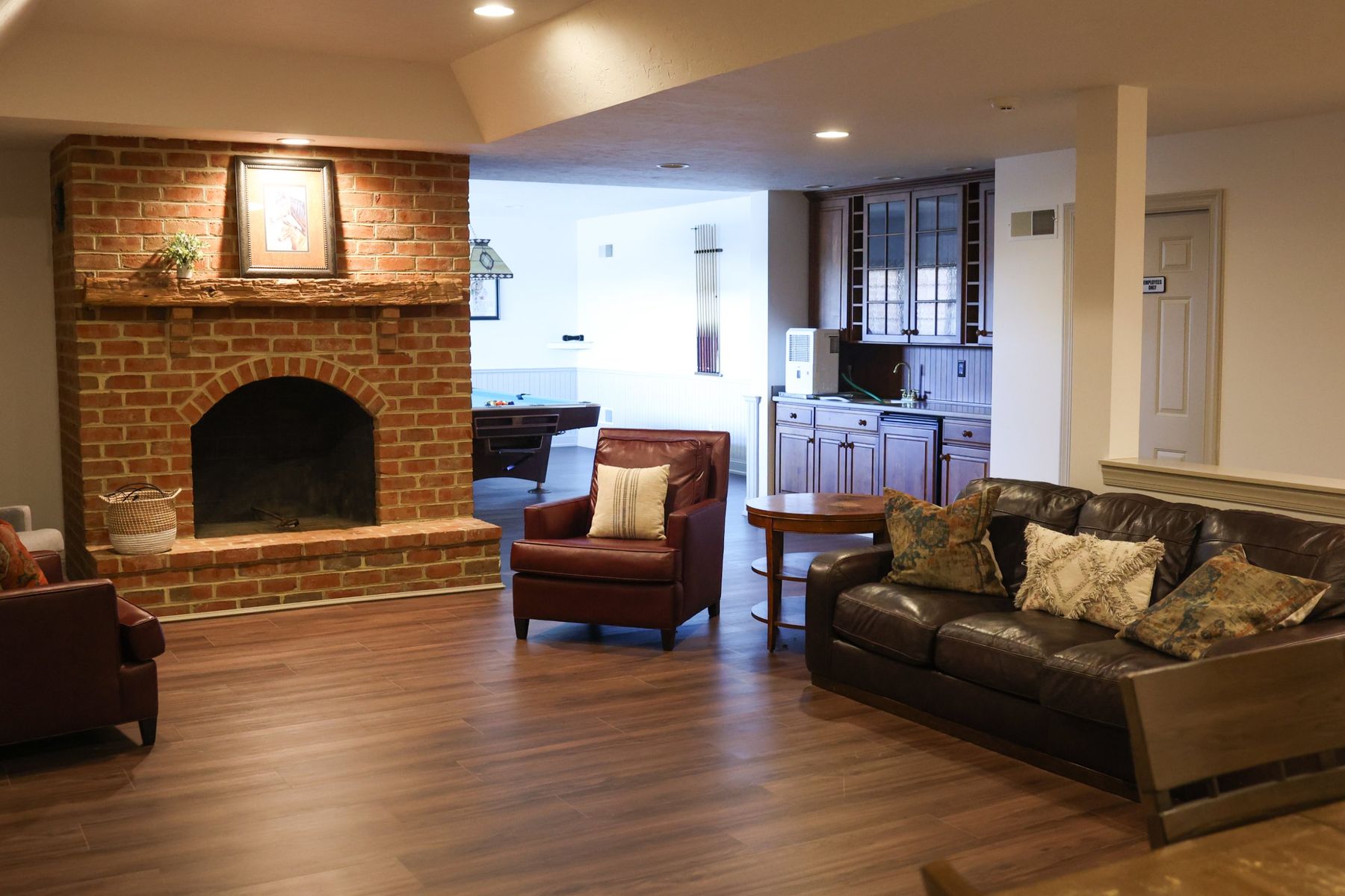 The lower-level lounge with a brick fireplace and bar