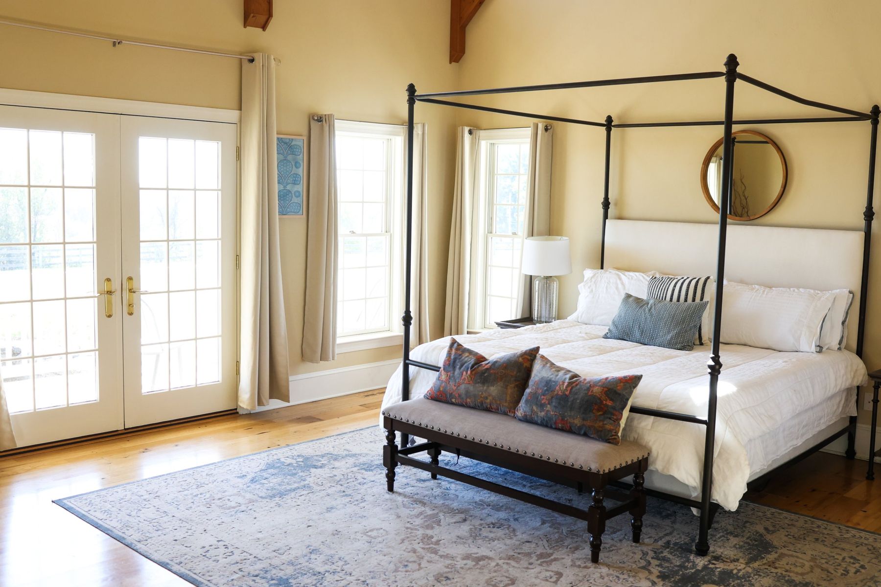 The master suite with a canopy bed and French doors